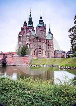 Magical fascinating landscape with famous Rosenborg Castle near pond in palace garden in Copenhagen, Denmark. Exotic amazing