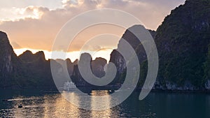 Magical golden sunset in Halong Bay in Vietnam, South China Sea. Cruise Sails liner ship wooden junk sailing rock islands the