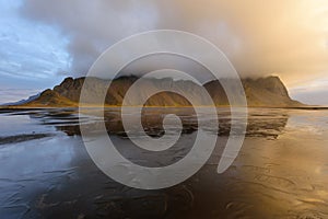 Magical landscape of Vestrahorn Mountains and Black sand dunes in Iceland at sunrise.  Panoramic view of the Stokksnes headland in