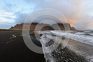 Magical landscape of Vestrahorn Mountains and Black sand dunes in Iceland at sunrise.  Panoramic view of the Stokksnes headland in