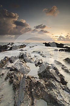 Magical light scenery of sunset sunrise Pandak Beach, Terengganu, Malaysia with unique rock formation and cloudy sky