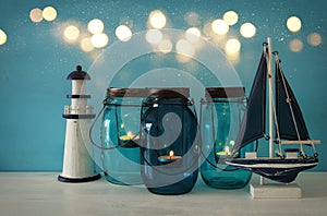 Magical mason jars whith candle light and wooden boat on the shelf