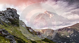 Magical Mountains Landscape. Majestic Sunset. Overkast sky over Rock Peak under sunlit. Awesome Alpine highlands in Summer Day.