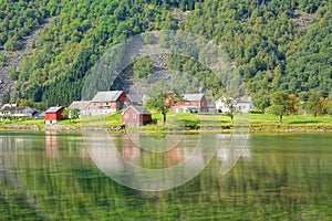 Magical Nature landscape with greenery, houses, water reflection