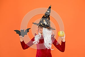 Magical spell. Small witch with white hair. Wizard or magician. Halloween party. Small girl in black witch hat. Autumn