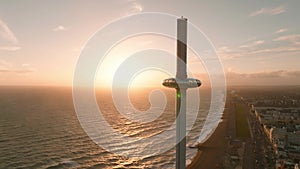 Magical sunset 4k aerial video of British Airways i360 viewing tower pod with tourists in Brighton