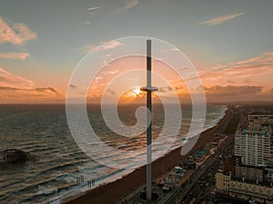 Magical sunset aerial view of British Airways i360 viewing tower pod with tourists in Brighton