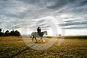 Sunset landscape with a man and his son riding horses. photo