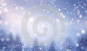 Magical winter background with snow,snowflakes and soft bokeh lights on blue sky,cold backdrop for Christmas. Snowy