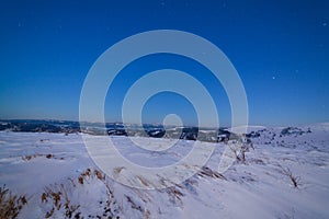 Magical winter landscape with snow covered tree. Vibrant night sky with stars and nebula and galaxy. Deep sky astrophoto