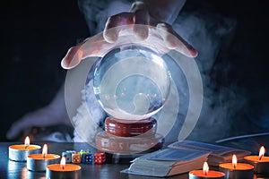 Magician or fortune teller is predicting future with crystal sphere.