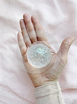 Magician hand of the sorceress holds a crustall in the shape of the moon.