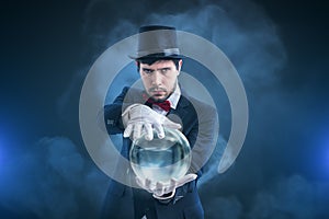 Magician or illusionist is fortune telling and predicting future from magical crystal ball photo