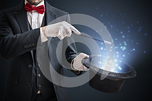 Magician or illusionist is showing magic trick. Blue stage light in background