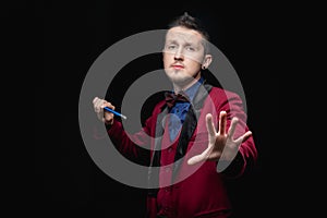 Magician man with magic wand on black background