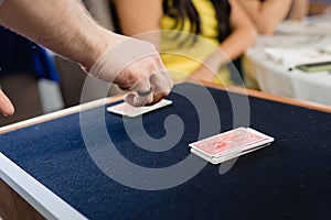 A magician performs a trick with cards face down on a mat