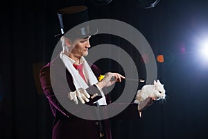 Magician with rabbit, Juggler man, Funny person, Black magic, Illusion on a black background