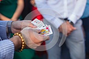 Magician showing card tricks focus in front of guests on party event wedding celebration, juggler performing show