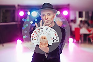 Magician showing trick with playing cards. Magic, circus