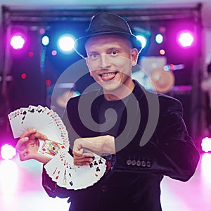 Magician showing trick with playing cards. Magic, circus