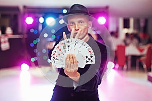 Magician showing trick with playing cards. Magic, circus