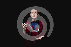 Magician shows focus with playing cards on black background