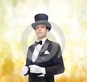 Magician in top hat with magic wand showing trick