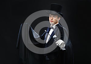 Magician in top hat with magic wand showing trick