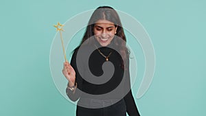 Magician witch indian woman gesturing with magic wand making wish come true, casting magician spell