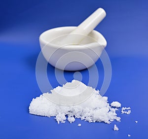 Magnesium nitrate powder on light grey background.