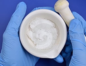 Magnesium nitrate powder on light grey background.