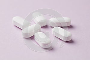 Magnesium with Vitamin B6 Tablets on pink paper background. Dietary supplement.