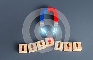 The magnet selects one person from the row. Finding the best recruiting candidate. Human resources. Search for the right person photo