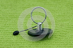 Magnetic bottle security tag on a green fabric