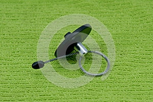 Magnetic bottle security tag on a green fabric