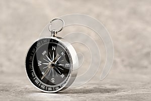 Magnetic compass on a grey stone background