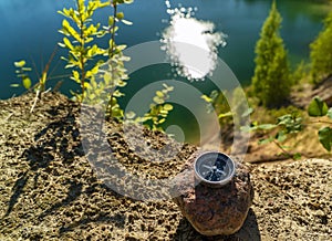 The magnetic compass lies on a stone at the edge of the reservoir .