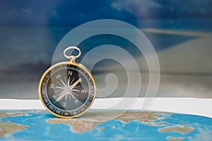 Magnetic compass on world map, concept of travel and destination