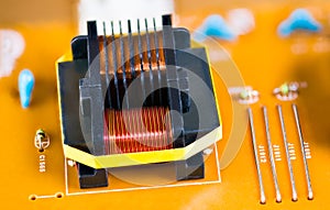 Magnetic ferrite core transformer detail on beige printed circuit board