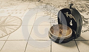 Magnetic old compass on world vintage  map.Travel, geography, navigation, tourism and exploration concept background.Macro shot,