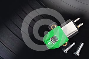 Magnetic phono cartridge and screws on vinyl record photo