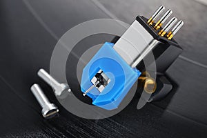 A magnetic phono cartridge on vinyl record disk