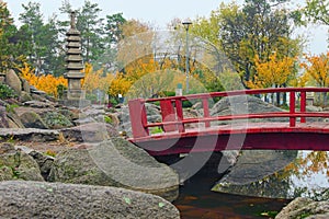 Magnificent autumn landscape view of a red wooden bridge at the Japanese Garden inside the Kyoto Park in Kyiv