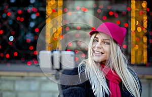 Magnificent blonde girl tourist wearing funny hat, taking selfi