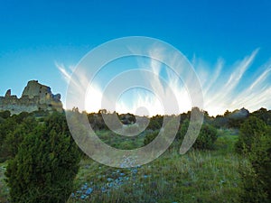 Magnificent blue sky embellished with frayed white clouds which embellish the landscape with the castle of Queen Jeanne next to it photo