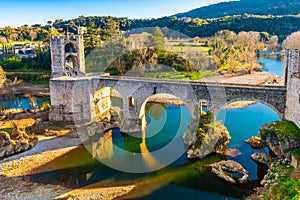 Magnificent bridge and its reflection, of the medieval village of Besalu in Catalonia, Spain