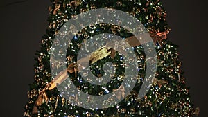 A magnificent Christmas tree, with flickering lights and Christmas decorations on Moscow`s city square at night. Close