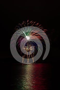 Magnificent colorful stars and fountain from rich fireworks over Brno`s Dam with lake reflection