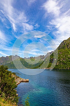 Magnificent fjord in lofoten islands in norway with blue water and cloudy sky over high mountains