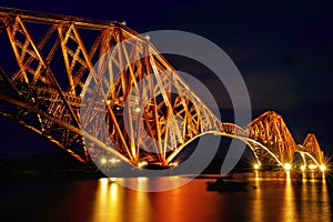 The magnificent Forth Bridge lit up at night.